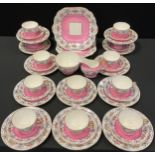 An Aynsley teaset, for twelve, decorated with a band of pink roses, flowers and butterflies