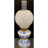 A Meissen design blue onion pattern oil lamp, Hinks patent wick adjuster; frosted globular shade,
