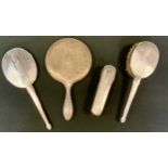 A silver mounted dressing table set, hand mirror, clothes brush and hair brush, Birmingham 1947;