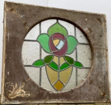 A 19th century stained glass window, stylised rose within a circular panel, mounted in a rectangular