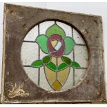 A 19th century stained glass window, stylised rose within a circular panel, mounted in a rectangular