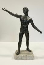 A bronzed spelter figure, 'Male Gymnast standing with arms extended', mounted on a white marble