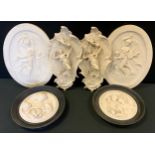 A pair of Bas-relief reconstituted stone wall plaques, Putti, ebonised frames, 24cm diameter; others