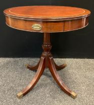 A 20th century reproduction mahogany drum table, tan leather top, pair of drawers to frieze,