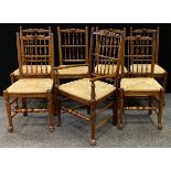 A set of Nigel Griffiths style oak spindle-back dining chairs, comprising six chairs and a single