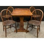 A mid 20th century oak draw-leaf table and set of four 'Ercol' style spindle-back chairs, (each with