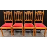 A set of four Arts and Crafts oak dining chairs, carved serpentine top rail, fretwork splats, drop-