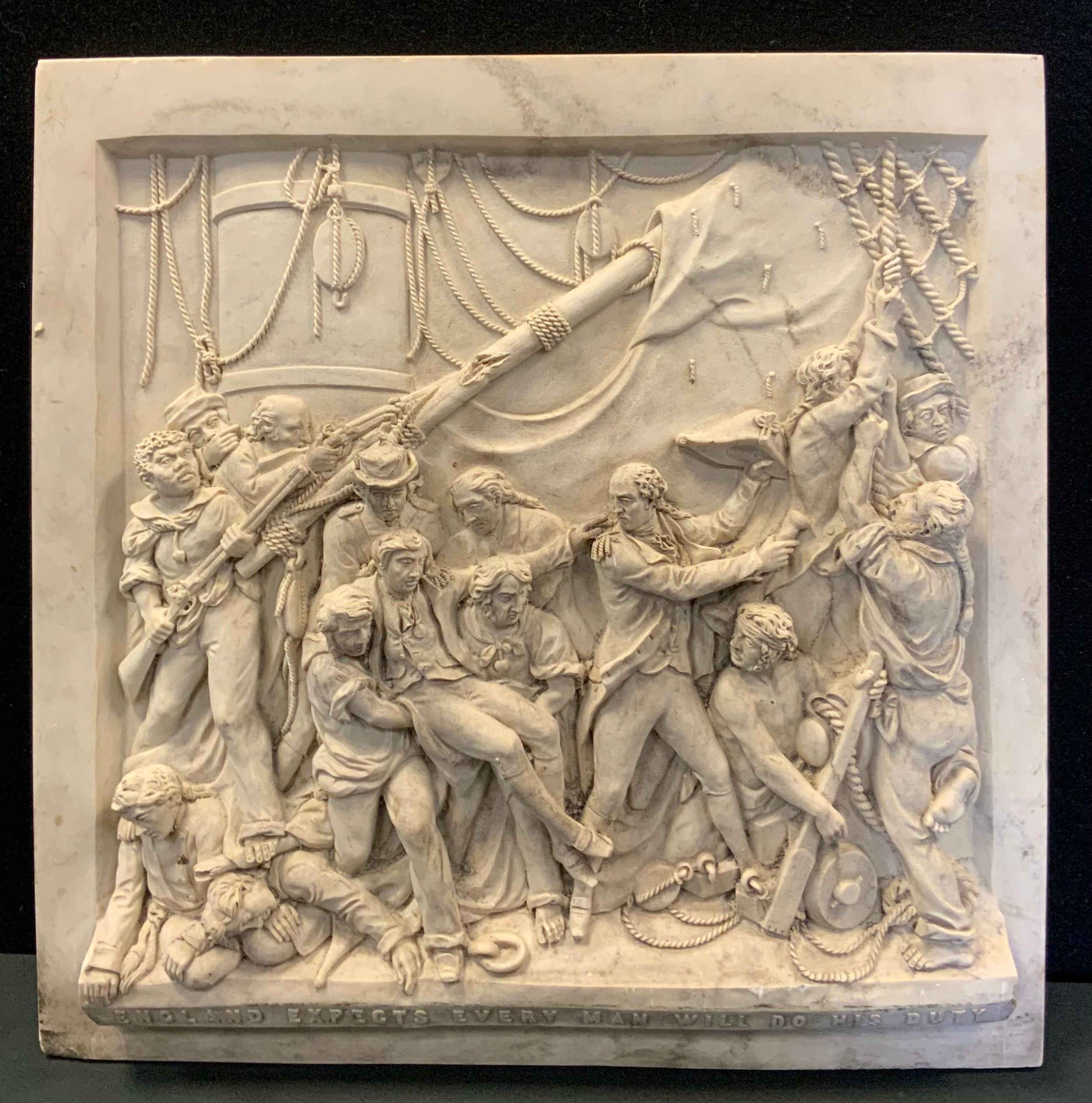 A Bas-relief reconstituted stone wall plaque depicting The Death of Nelson, the bottom plinth