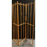 A wrought iron two light floor standing candelabrum, 154cm high; a three fold divider (2)