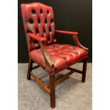 A mid 20th century button-back open arm office chair, sang de boeuf leather, mahogany arms and legs,