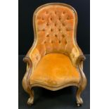 A Victorian upholstered walnut arm chair / nursing chair, shaped button back and stuffed-over seat