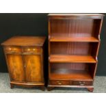 A mahogany waterfall bookcase, three tiers of shelving above pair of drawers to base, 122cm tall x