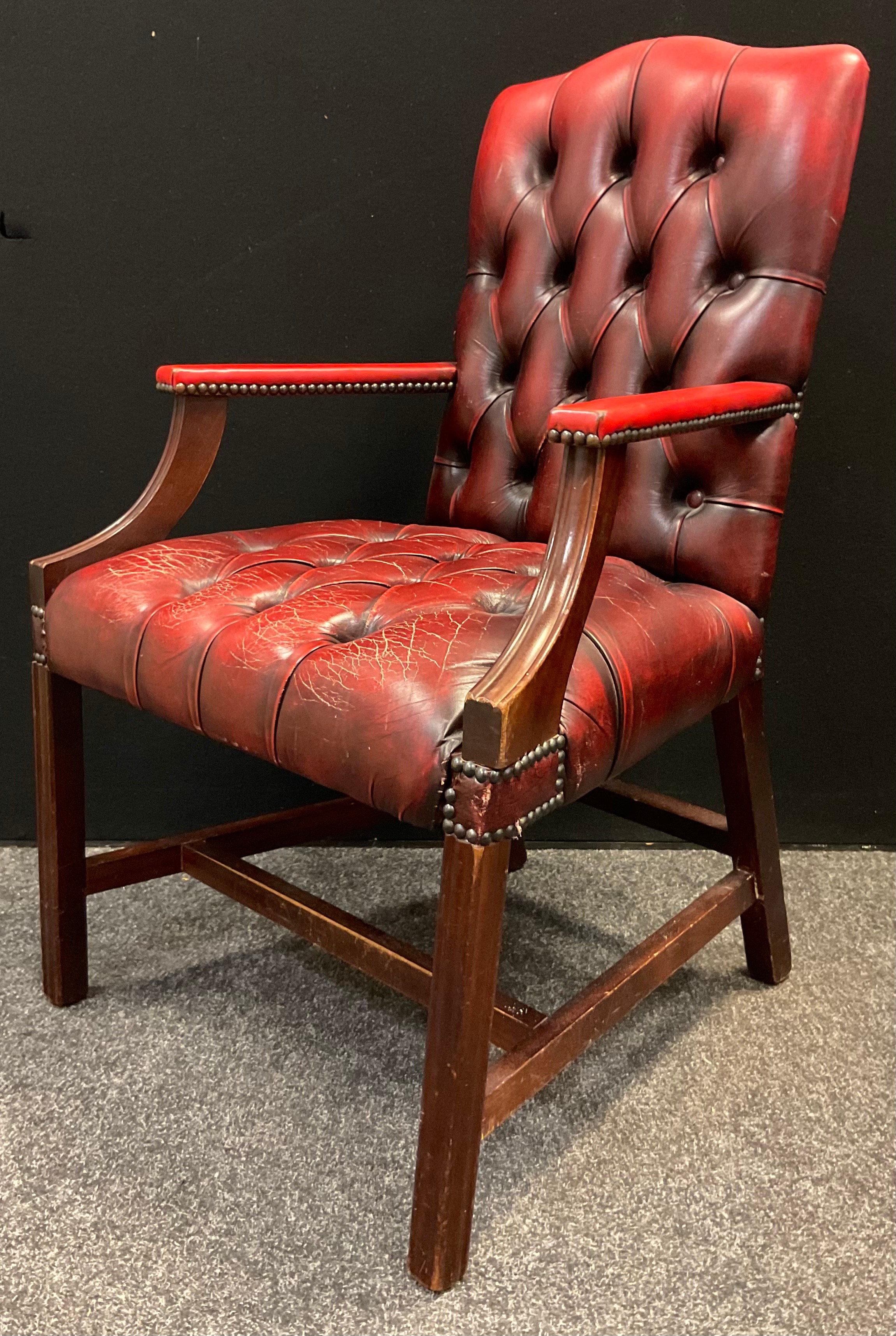 A mid 20th century button-back open arm office chair, sang de boeuf leather, mahogany arms and legs,