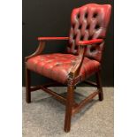 A mid 20th century button-back open arm office chair, sang de boeuf leather, mahogany arms and legs,