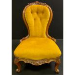 A Victorian upholstered walnut nursing chair, shaped button back with carved cresting, carved side