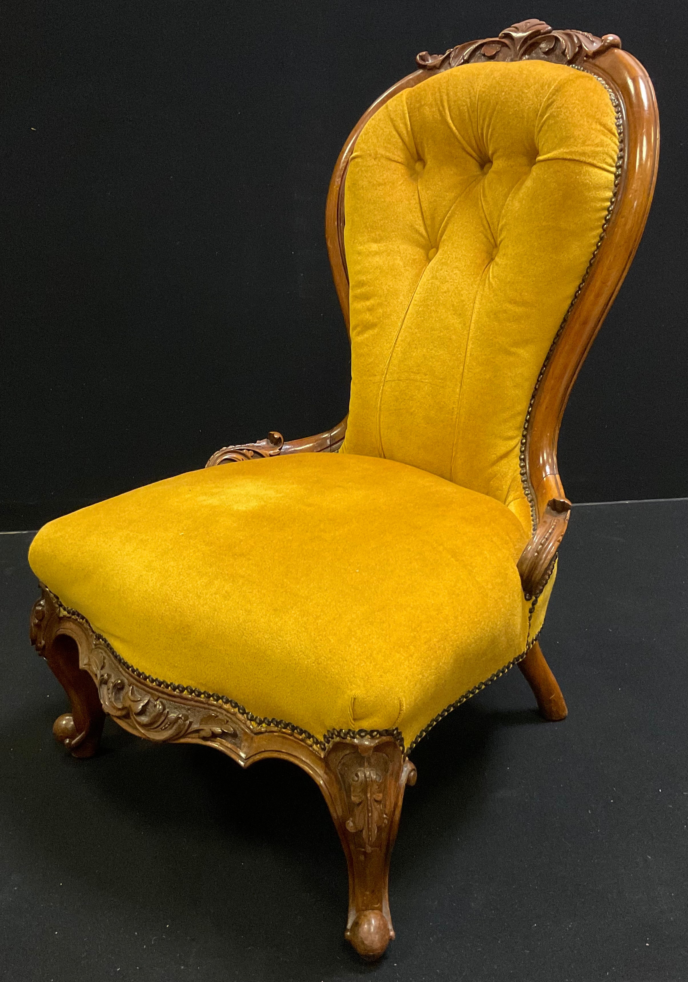 A Victorian upholstered walnut nursing chair, shaped button back with carved cresting, carved side - Image 2 of 2