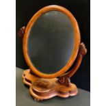 A Victorian mahogany dressing table mirror, oval mirror with carved supports, above a serpentine