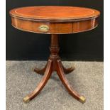 A 20th century reproduction mahogany drum table, tan leather top, pair of drawers to frieze,