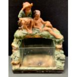 An early 20th century painted chalk ware/plaster model, of two boys above a glass fish tank, 52cm