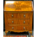 A mid 20th century walnut bureau, fall door enclosing a fitted interior, above three drawers,