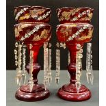 A pair of 19th century bohemian ruby red glass table lustres, painted with floral and leaf bands,