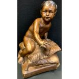 A bronze coloured chalk/plater figure, child seated upon cushions, 41cm high.