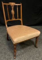 A Victorian carved and inlaid mahogany nursing chair, shaped cresting, floral inlaid central