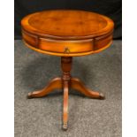 A contemporary yew wood drum table, pair of drawers to top, pedestal base, reeded cabriole legs,