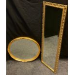 An oval looking glass, gilt frame, 57cm x 67cm; another, dressing mirror, 124cm tall, (2).