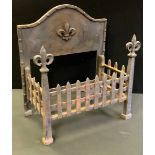 A Victorian cast iron fire grate, serpentine shaped back with fleur-de-lys decoration, matching