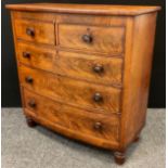 A Victorian mahogany bow-front chest of drawers, two short over three graduated long drawers, turned