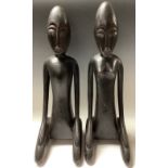 African Art - a pair of ebonised stylised figrues, kneeling, 51cm high