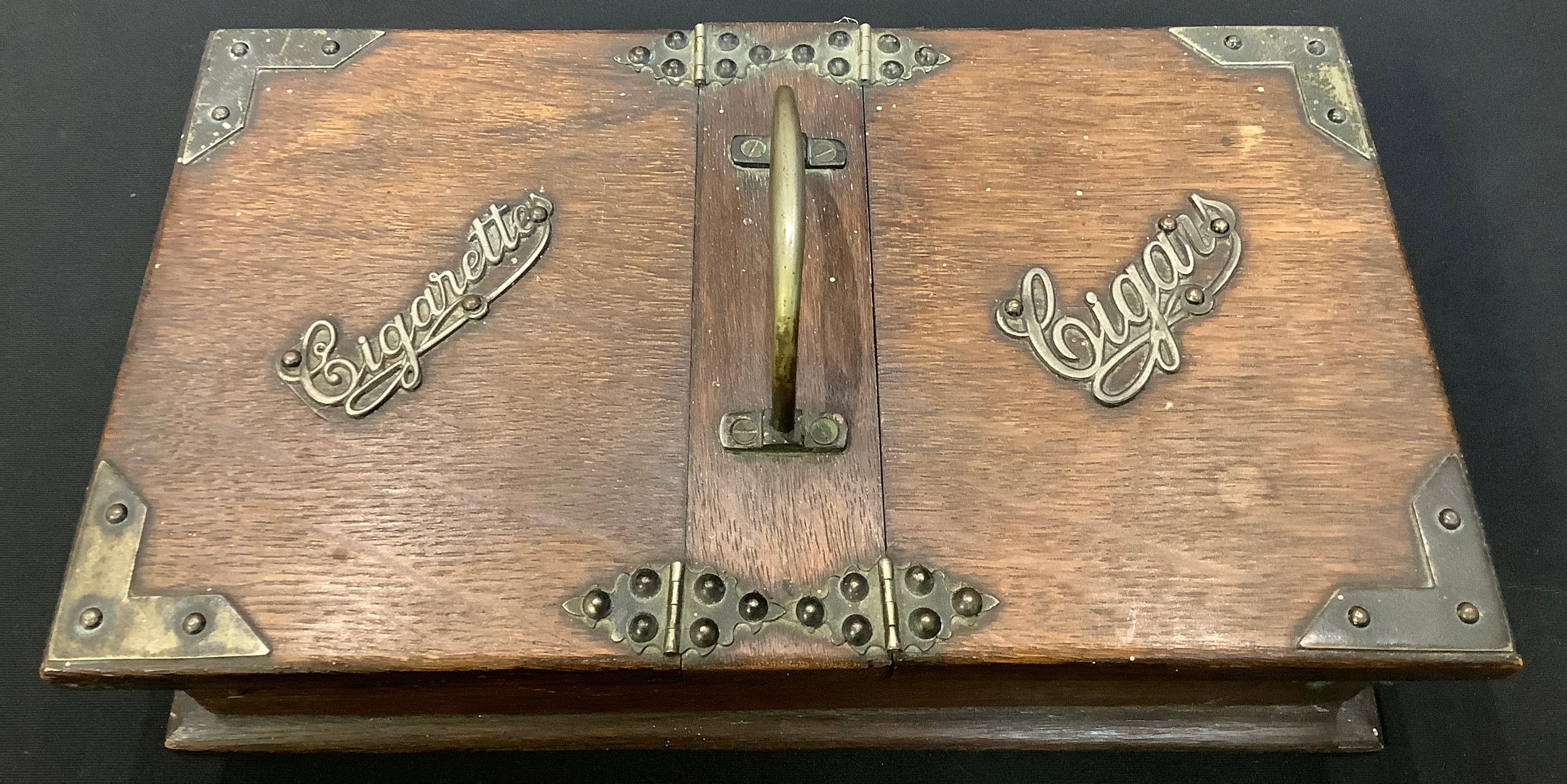 An early 20th century E.P.N.S mounted oak tobacco waiter, the hinged covers labelled Cigarettes