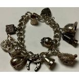 A silver charm bracelet with padlock, Birmingham 1958, eleven charms