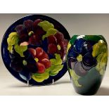 A Moorcroft Clematis pattern plate, tube lined with bold flower heads on a cobalt blue ground,