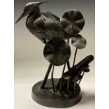 A French dark patinated spelter model of a heron amongst lily pads, 37cm high