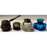 An early 20th century travelling inkwell; a blue glass inkwell; a clear glass inkwell with buble