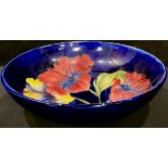 A Moorcroft Hibiscus pattern bowl, tube lined with bright flowerheads on a cobalt blue ground, 23.