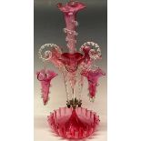 A Victorian Cranberry glass table epergne, the central flared trumpet, applied with clear