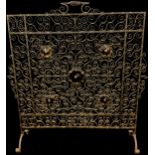 An early 20th century hand made wrought iron fire screen, set with five yellow glass roundels,