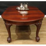 A George II Revival mahogany extending dining table, discorectangular top with two additional