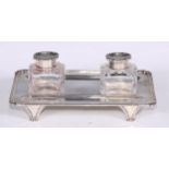 An Edwardian silver rounded rectangular inkstand, cut glass wells with hinged cover, gadrooned