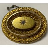 A 19th century Etruscan Revival 15ct gold stepped oval target mourning brooch, the centre star cut