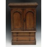 An early 20th century oak miniature linen press, moulded outswept cornice above a pair of arched