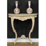A Rococo Revival painted console table, oversailing serpentine top above a frieze drawer, carved
