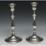 A pair of George III silver table candlesticks, fluted campana sconces and baluster pillars, batwing