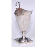 A George III silver helmet shaped cream jug, bright-cut engraved with leafy swags and a ribbon-