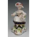 A Derby Patch Mark figure, of a girl seated holding a basket of flowers, scroll base, 12.5cm high,