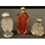 A cut glass silver topped pedestal scent bottle, Birmingham 1909; another; a ruby glass scent bottle