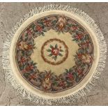 A circular woollen rugn with stylised dlowers on a cream ground, 102cm diam; another, similar